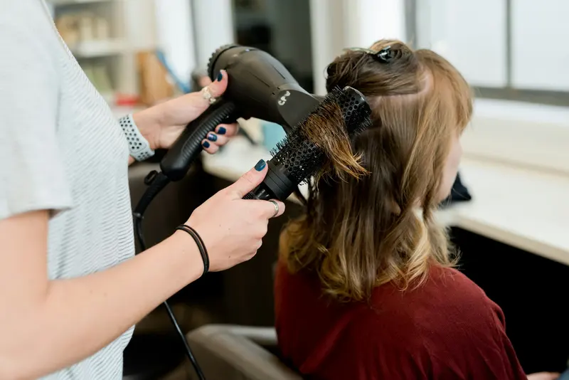 Coiffeuse réalisant un brushing