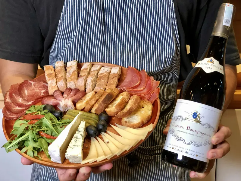 Planche de charcuterie et de fromages avec une bouteille de vin