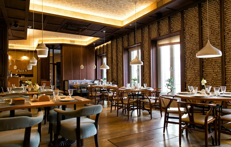 La salle du restaurant, chaleureuse, avec ses tables en bois