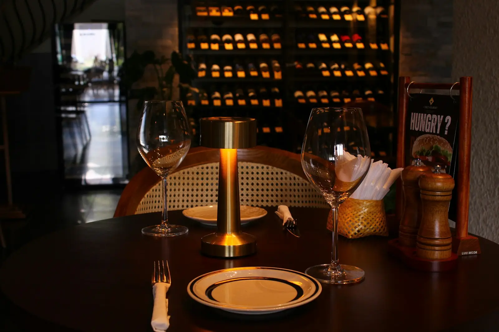 Table dressée à la lueur d'une lampe, verres à vin